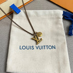 Louis Vuitton gold LV pendant necklace on chain, shown over white pouch