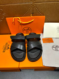 Black leather sandals with two wide cross straps and buckle detail