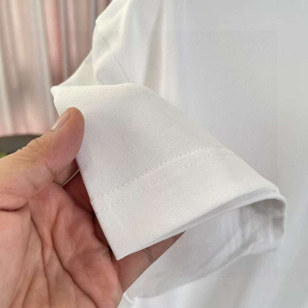 White Louis Vuitton T-shirt sleeve cuff and hem seam, held by hand