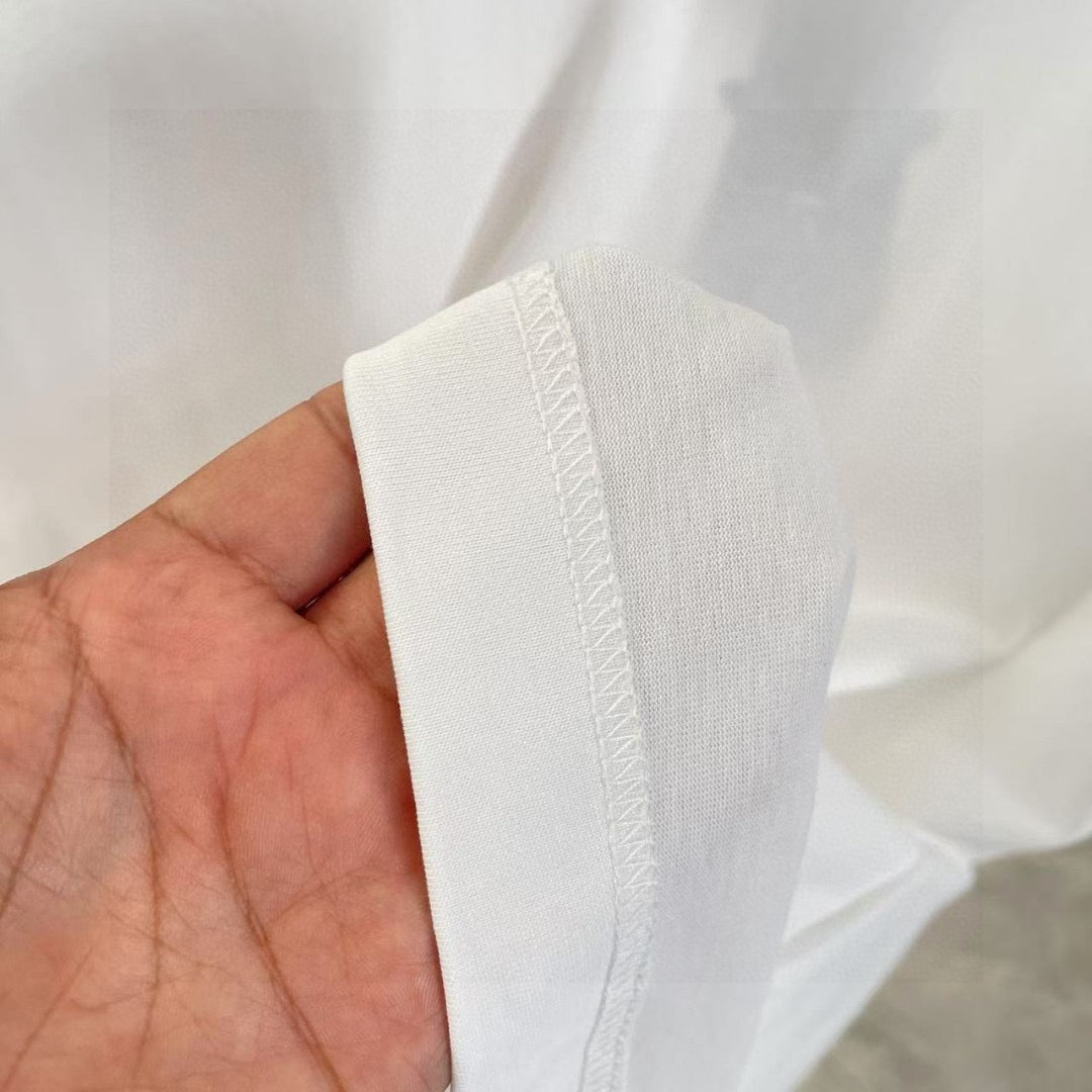 White Louis Vuitton T-shirt side seam and textured knit, held in hand