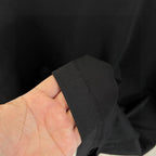 Louis Vuitton black T-shirt fabric held in hand, matte texture