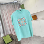 Turquoise crewneck T-shirt with centered multicolor emblem graphic on front