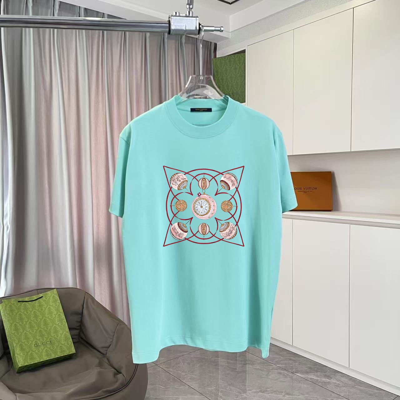 Turquoise crewneck T-shirt with large multicolor geometric emblem graphic on front