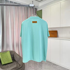 Turquoise T-shirt back with small rectangular logo patch near upper back