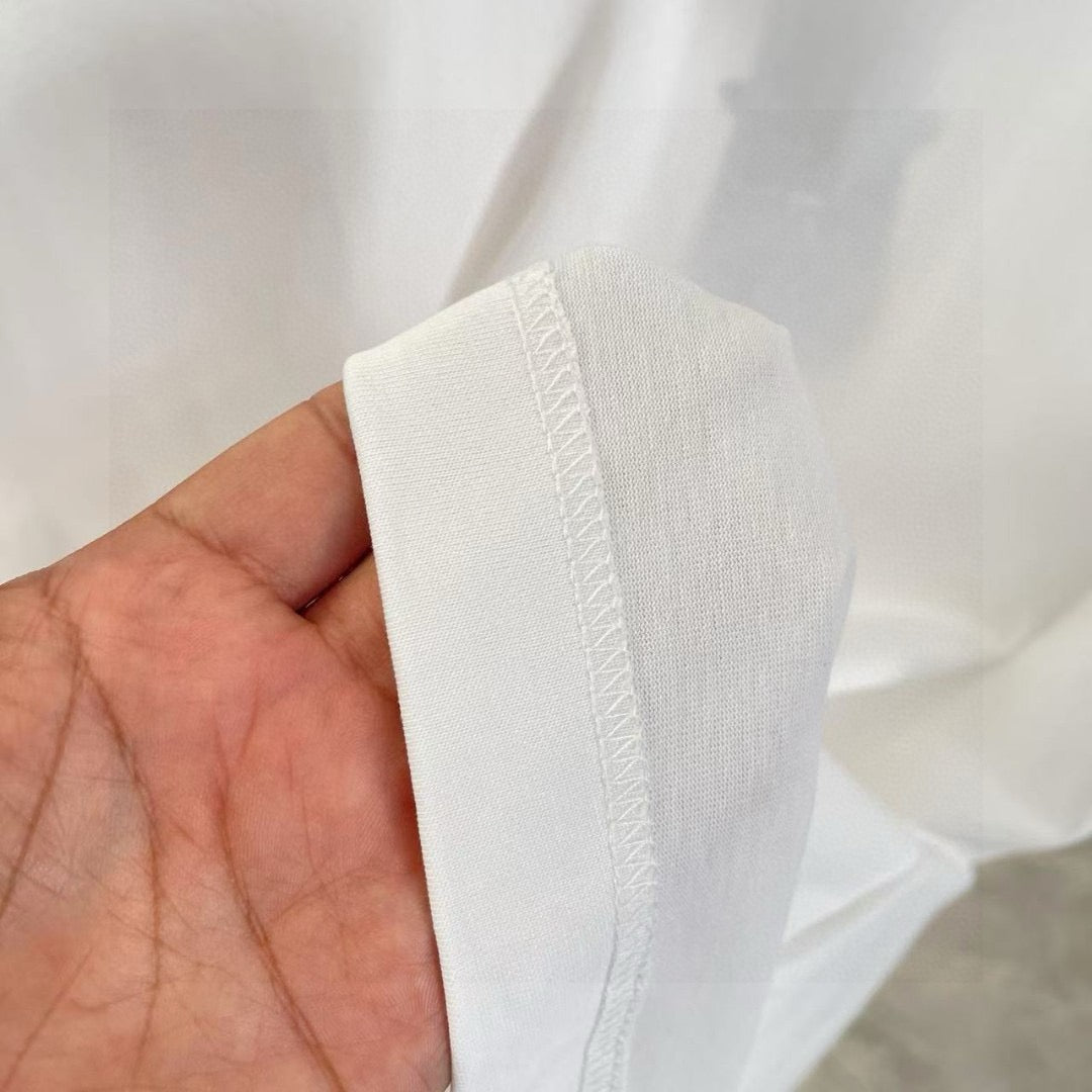 White T-shirt side seam and fabric texture close-up held in hand