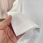 White T-shirt sleeve cuff and seam detail held in hand