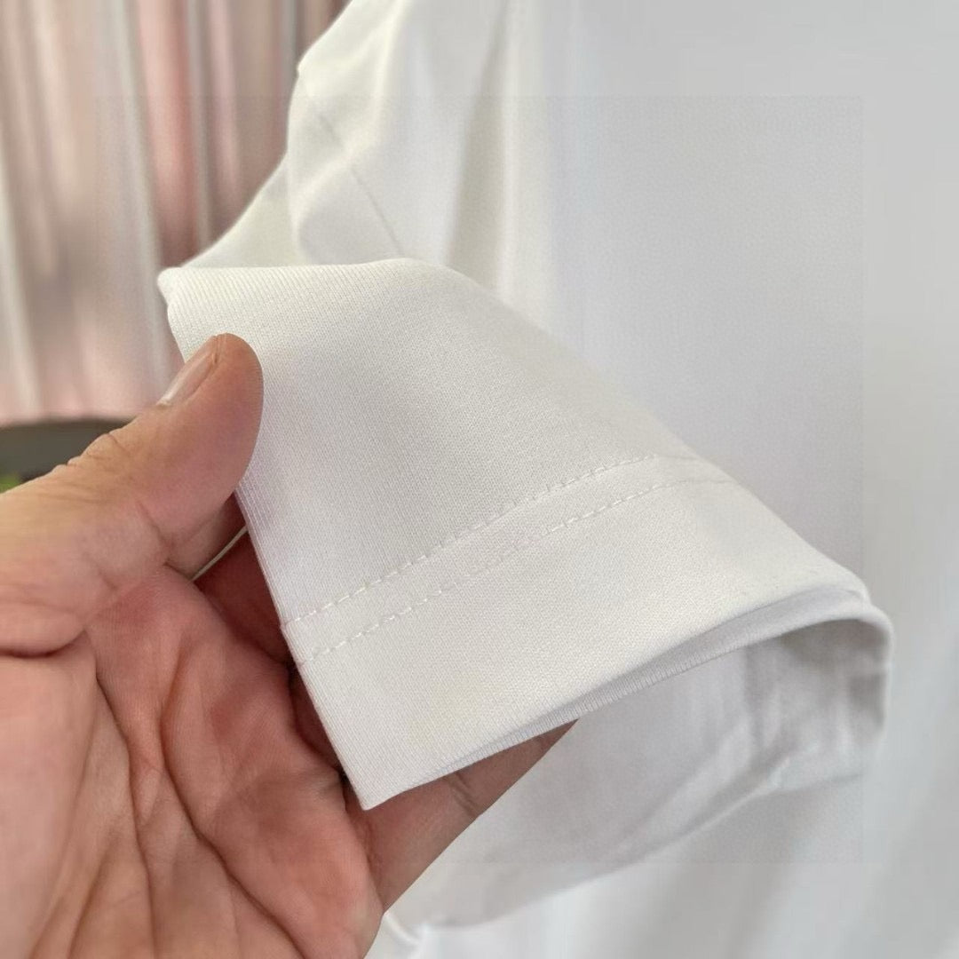 White T-shirt sleeve cuff and seam detail held in hand