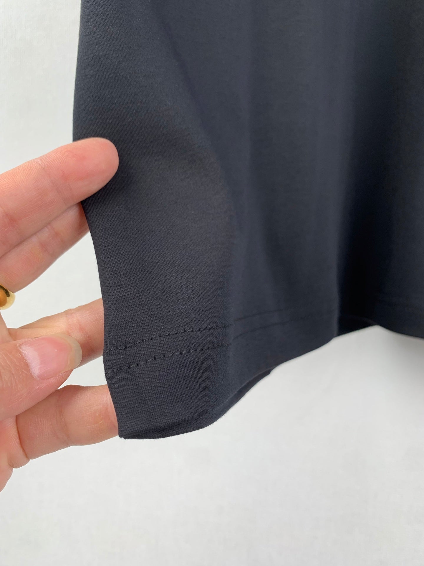 Gucci T-shirt sleeve fabric and hem seam close-up, dark blue