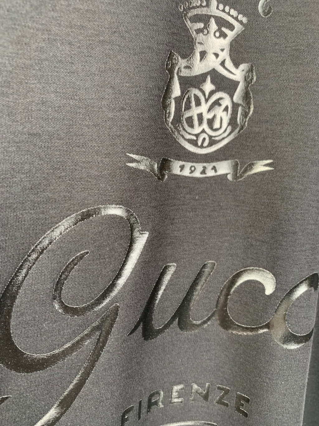 Gucci front graphic close-up with “Gucci” text and crest, dark blue