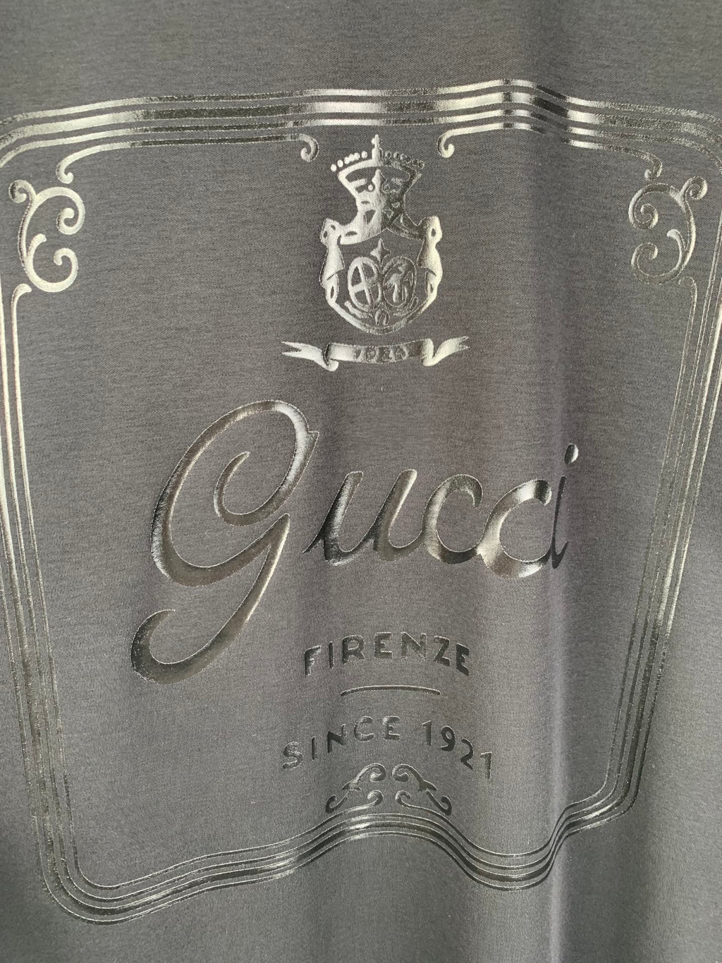 Gucci graphic panel close-up with crest and “Firenze” text, dark blue