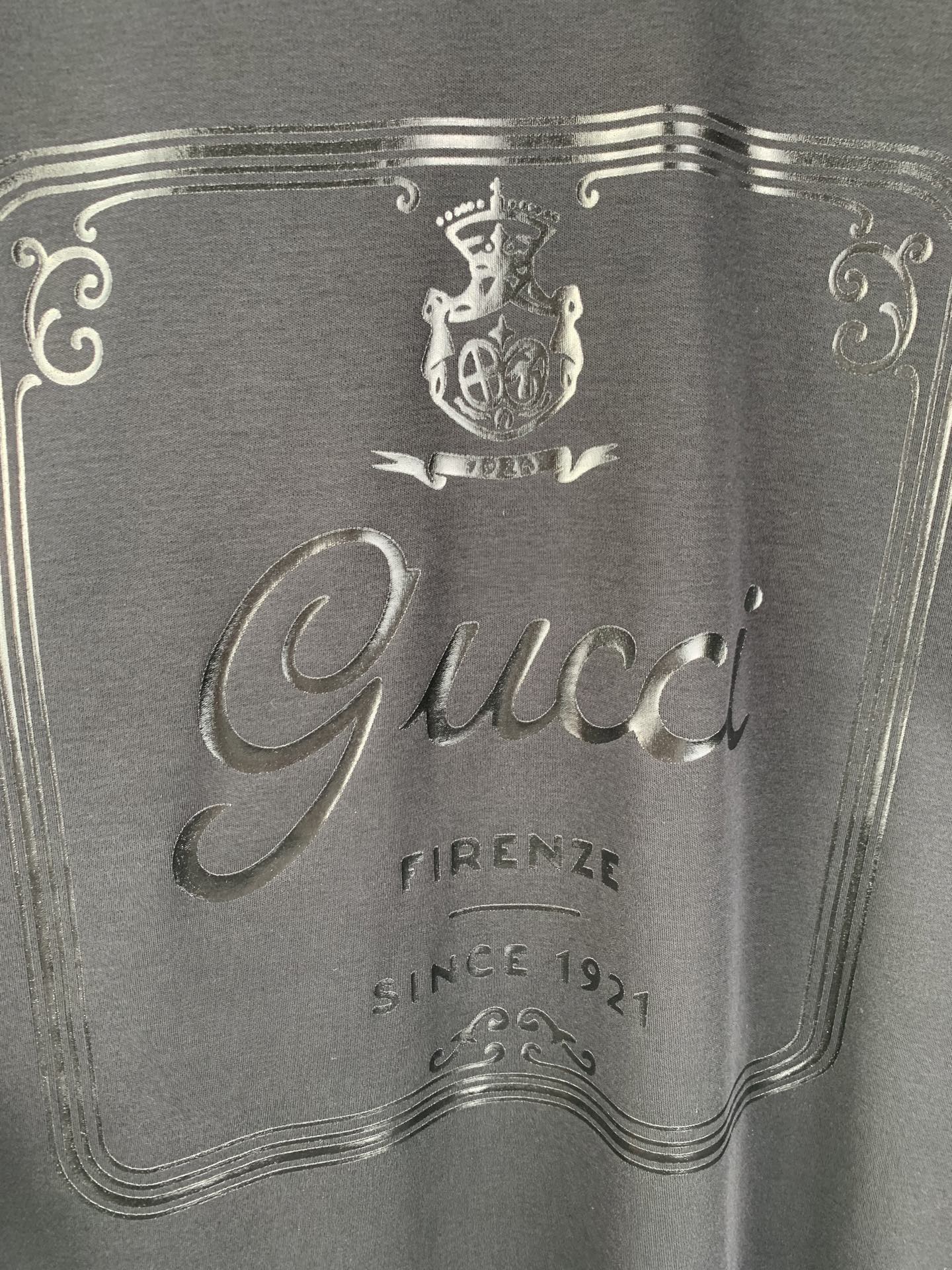Gucci graphic panel close-up with crest and “Firenze” text, dark blue