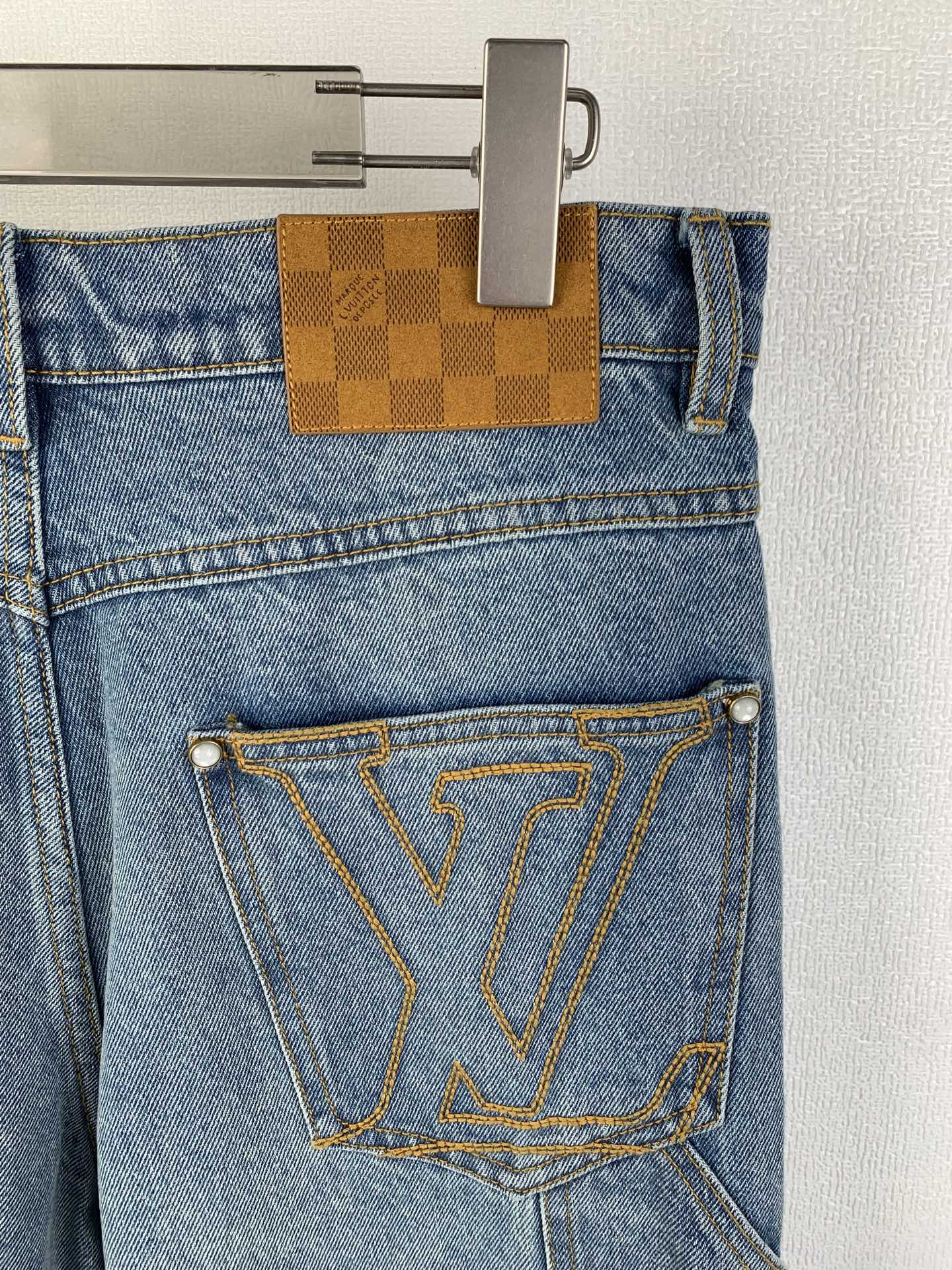 Louis Vuitton light blue denim pants with tan check pocket tab and LV-stitched emblem