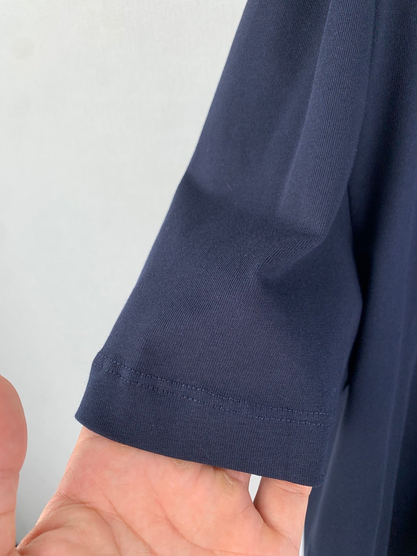 Navy short-sleeve garment cuff with stitched hem and seam detail
