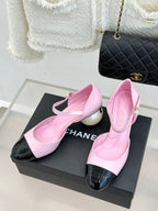 Pink Mary Jane flats with black patent toe cap and ankle strap, side view