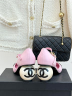Pink flats with black patent toe cap and ankle strap, heel detail visible