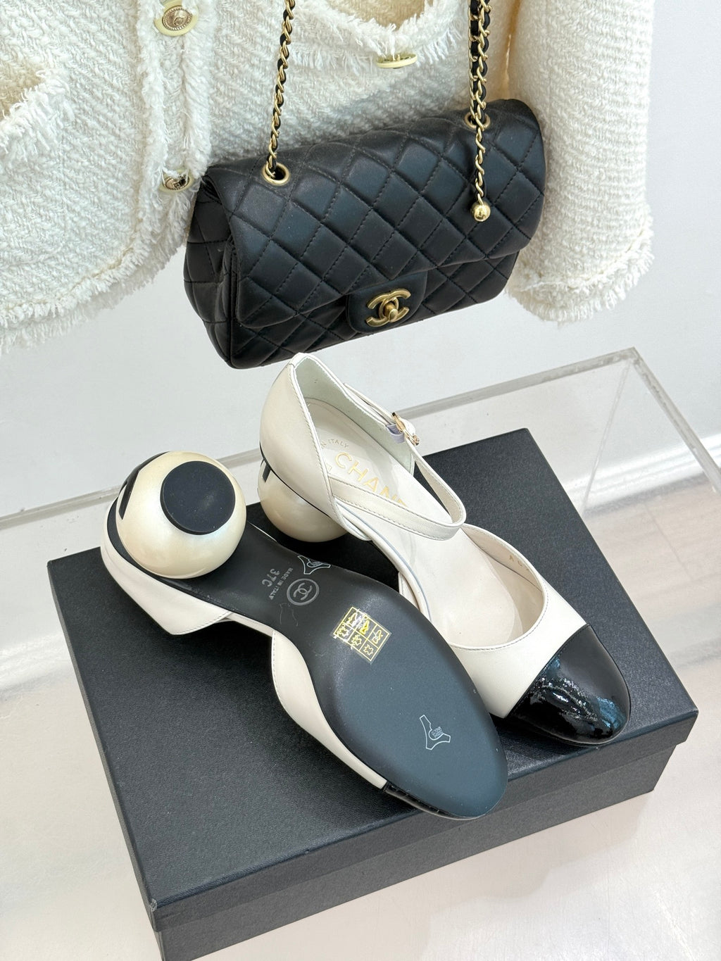 Chanel slingback pumps with white uppers and black patent toe, on display box