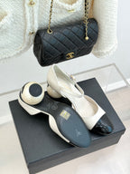 Chanel slingback pumps with white uppers and black patent toe, on display box