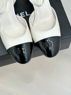Chanel slingback pumps close-up: white uppers with black glossy toe