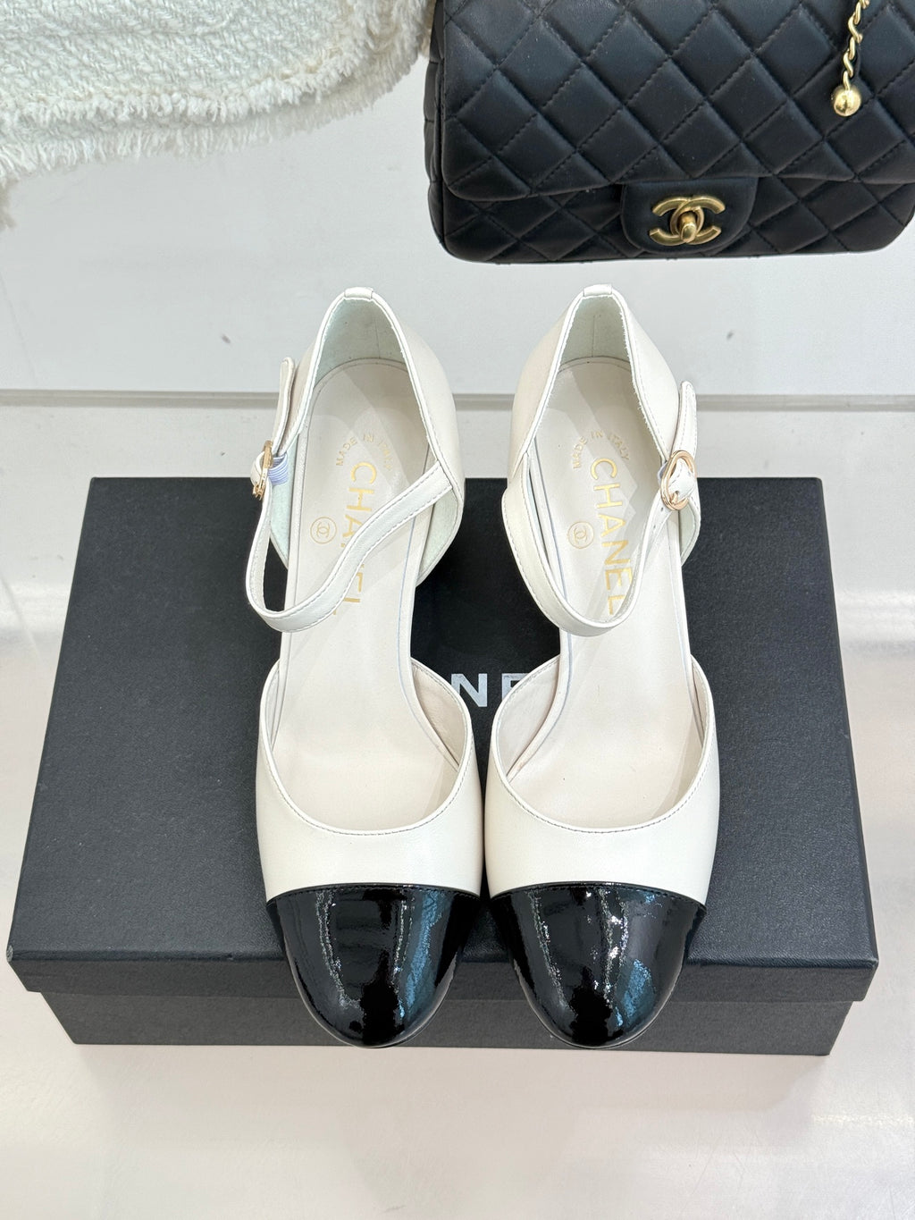 Chanel white slingback heels with black patent toe caps, pair front view