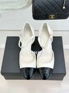 Chanel white slingback heels with black patent toe caps, pair front view