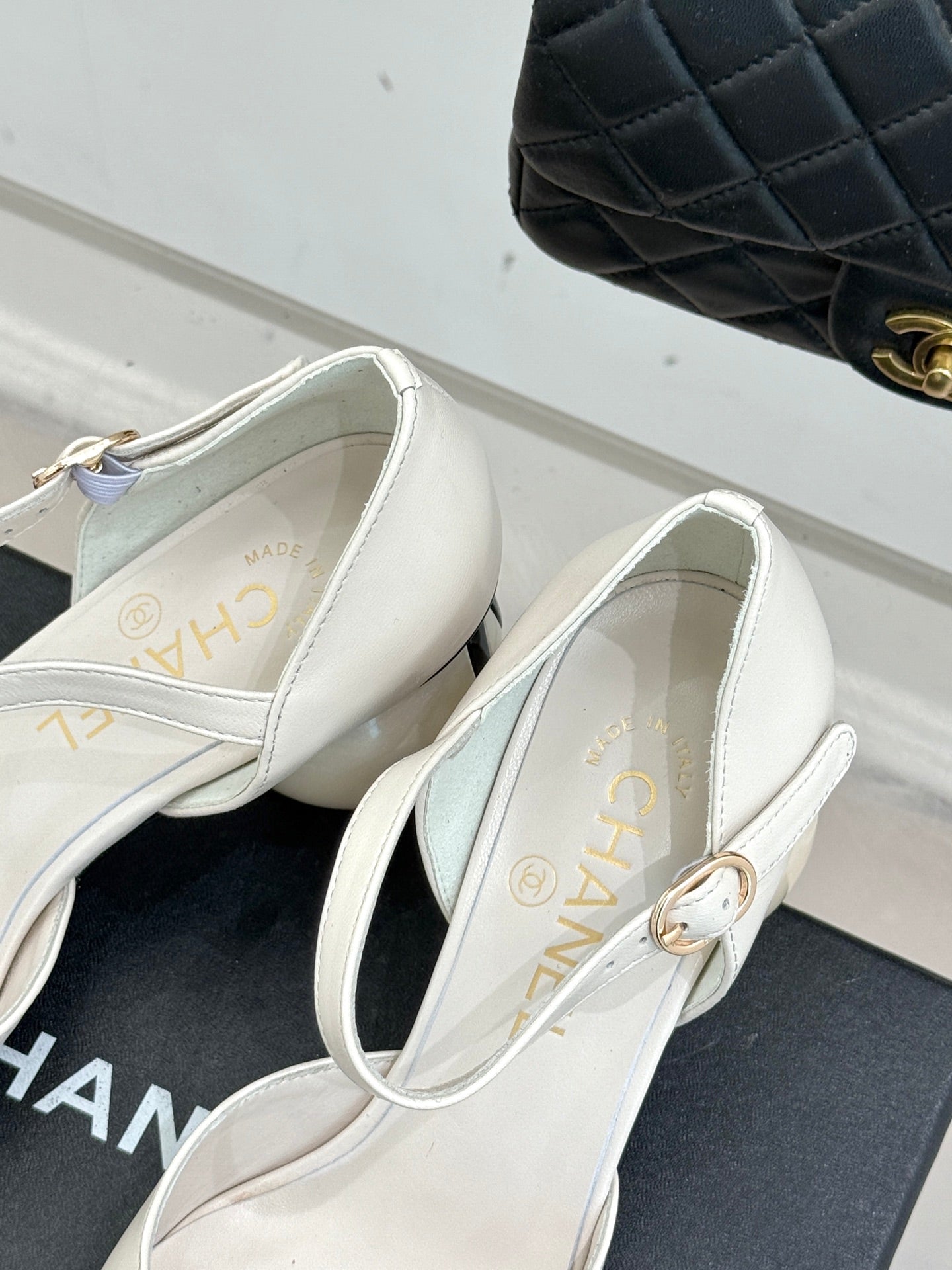 Chanel slingback pumps close-up, white leather with gold trim and black toe