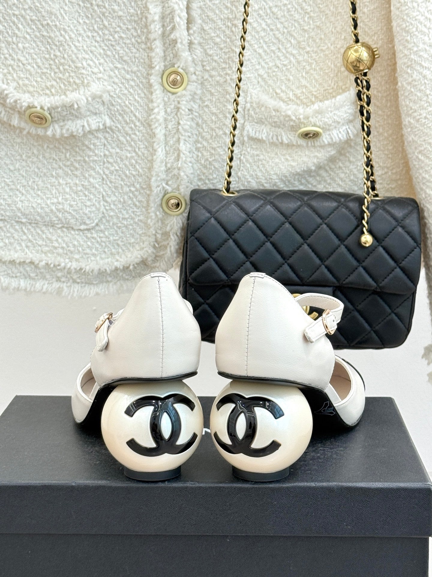 Chanel white slingback pumps with black patent toe caps, front view on box