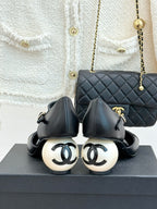 Black slingback flats with cream round heel detail and bow-tie accents