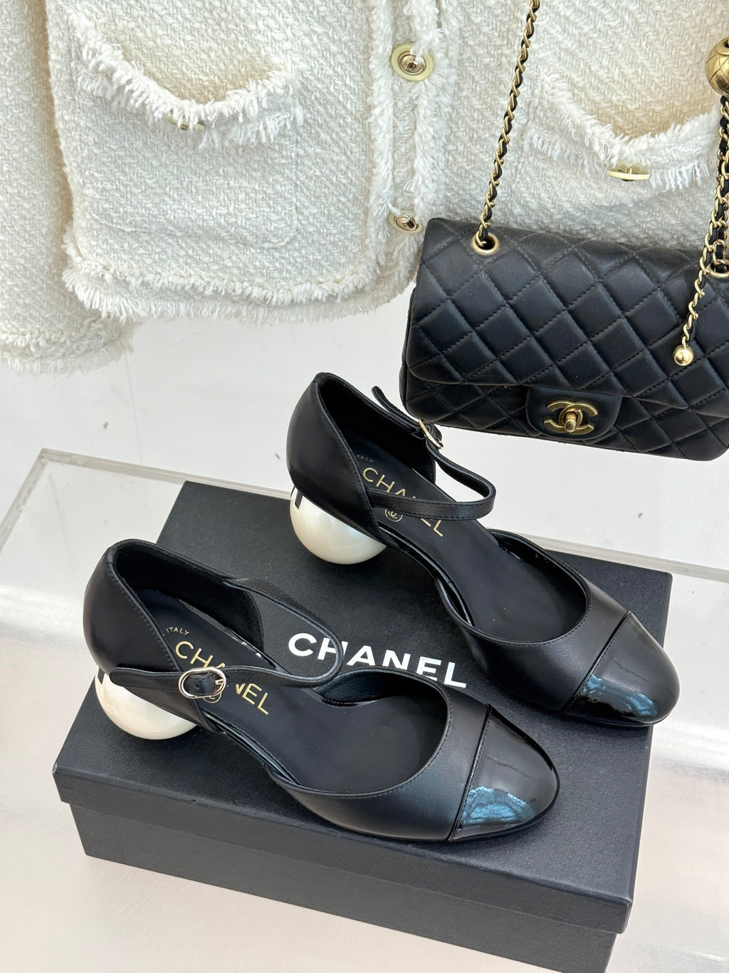 Pair of black pointed-toe flats with slingback strap and glossy cap toe