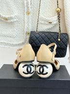 Beige slingback flats with black patent toe cap and bow strap, heel view