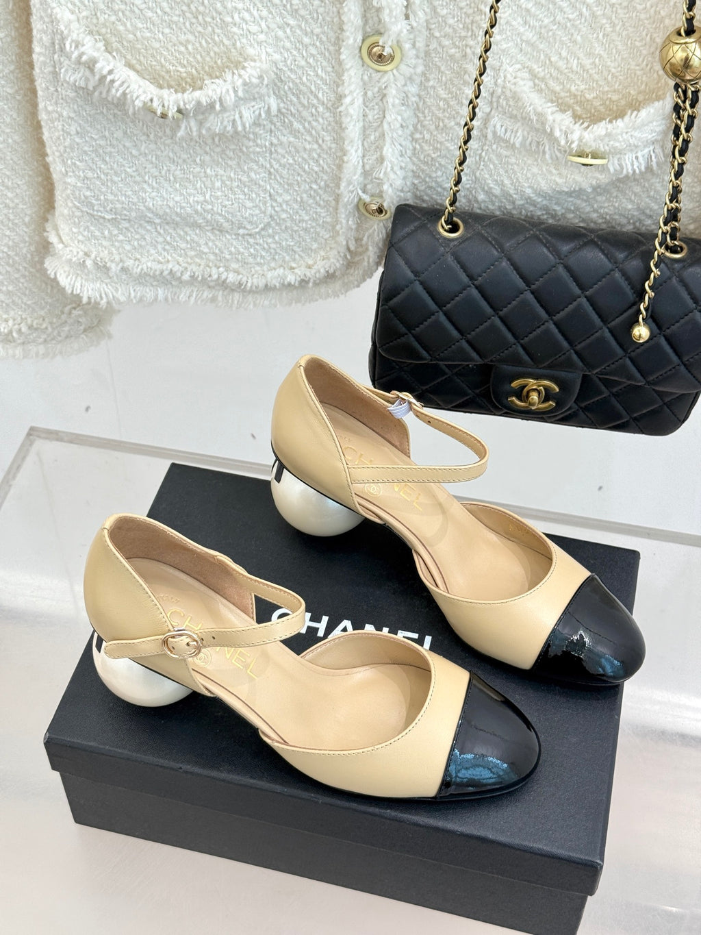 Beige slingback flats with black patent toe cap and bow detail