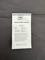 T-shirt care label on dark gray fabric with size and fabric info