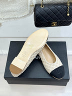 Chanel ballet flats with cream patterned uppers and dark navy logo toe caps on box