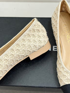 Chanel flats showing cream lace-texture upper and dark navy toe caps near heel