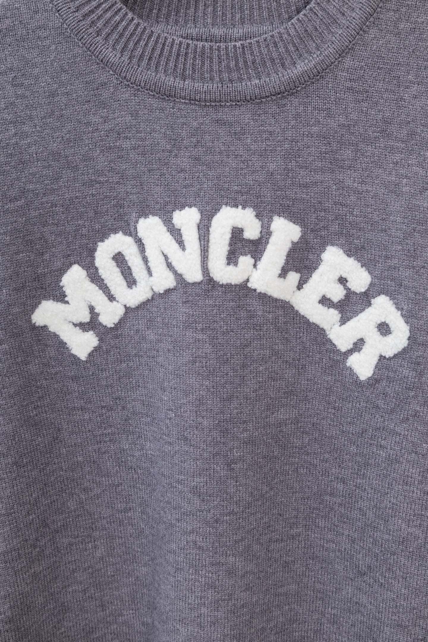Moncler grey knit sweater with large curved MONCLER lettering graphic