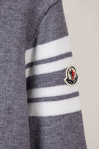 Moncler grey knit sweater sleeve showing white and dark striped trim and patch