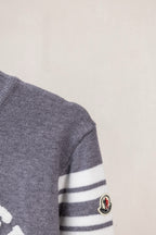 Moncler grey sweater sleeve with white striped band and round Moncler patch