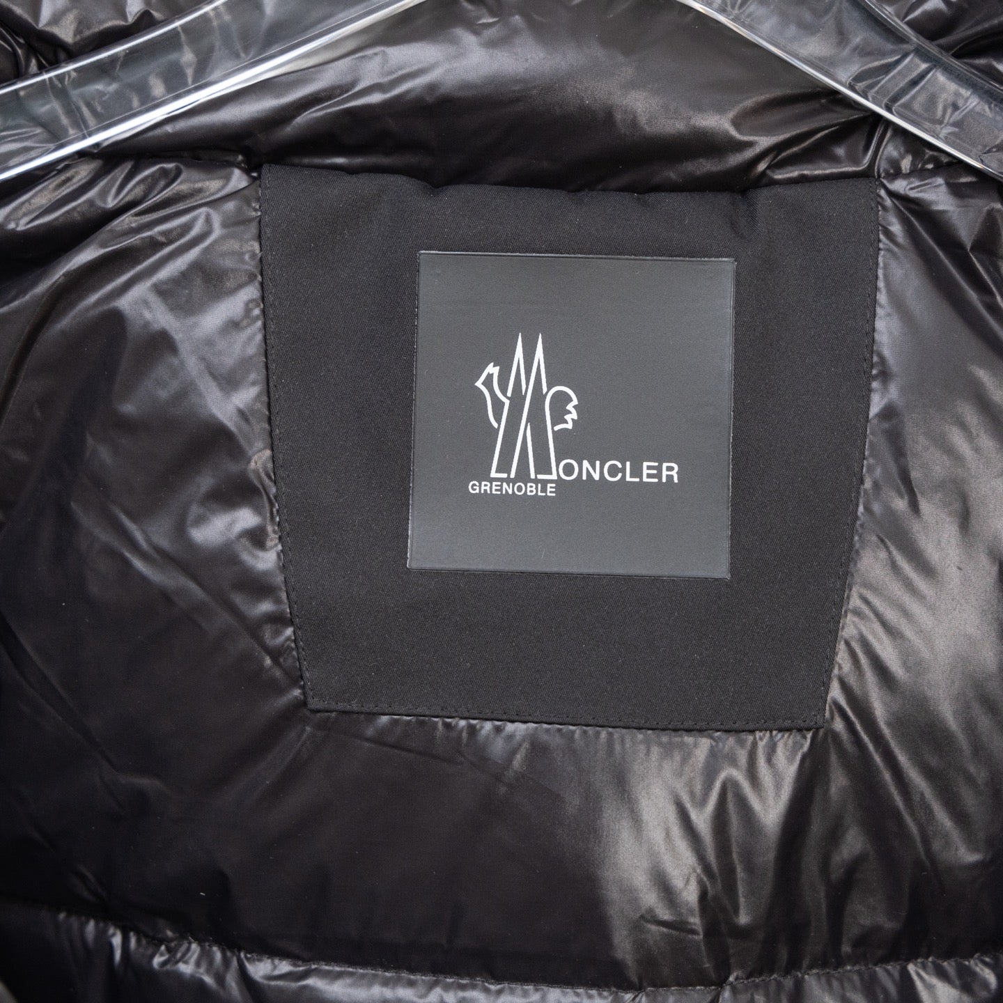 Moncler logo patch on black puffer lining
