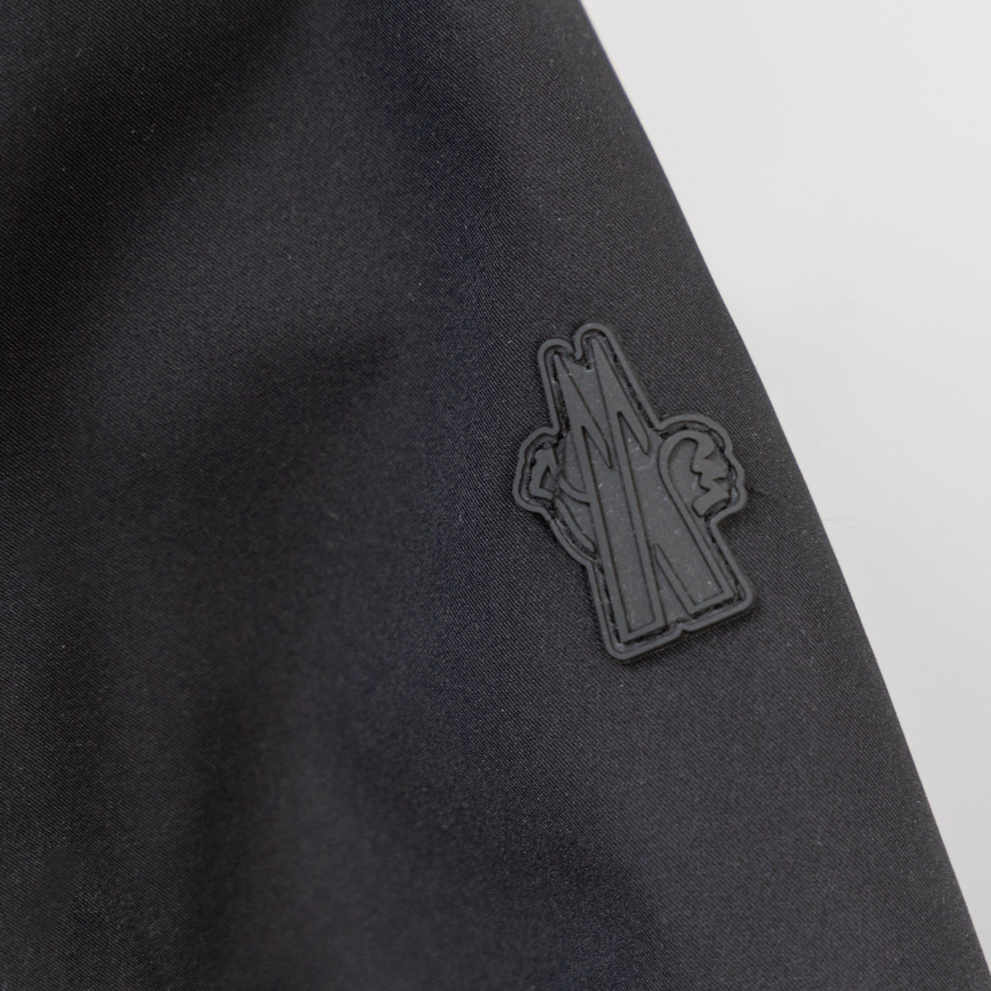 Moncler embroidered logo on dark parka fabric