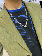 Silver-toned chain necklace with black enamel motif links on a blazer model