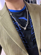 Silver-toned chain necklace with black enamel motif links on model torso