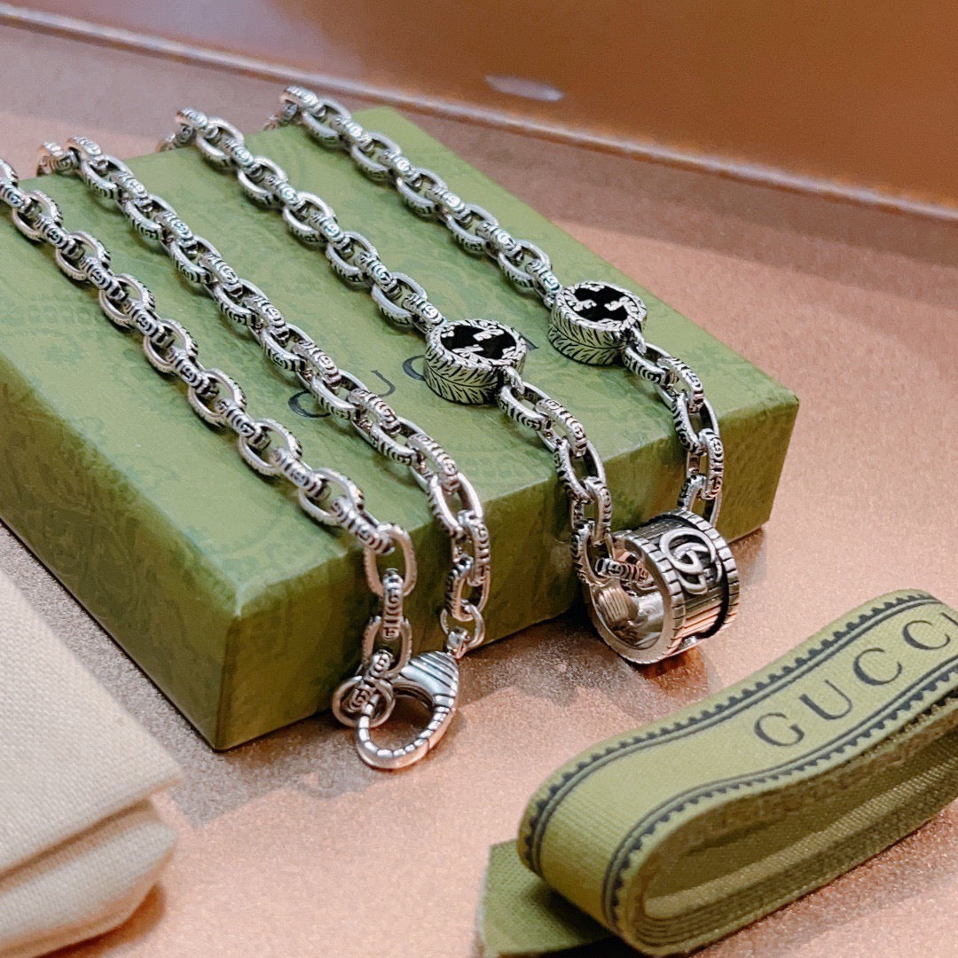 Silver-toned chain necklace with black enamel motifs and ring clasp