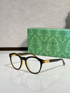 Tortoise brown eyeglass frames with clear lenses and gold-tone temple logo