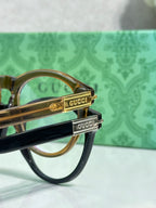 Gold-tone eyeglass temple with engraved logo detail on a brown frame