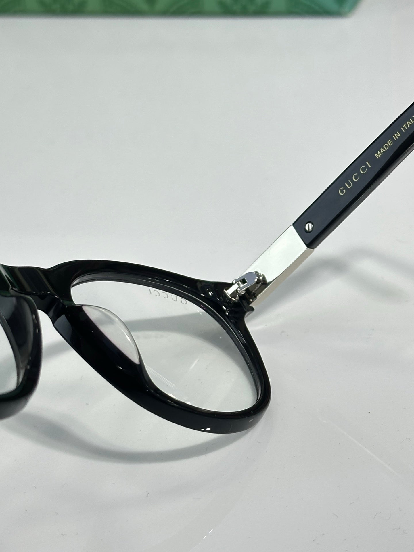 Black eyeglass frame with clear lenses and black temple marked 'Gucci'