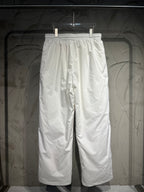 White track pants with elastic waistband and relaxed wide-leg silhouette