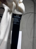White pants care label inside waistband area; shows Balenciaga brand and sizing text
