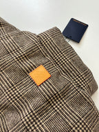 Houndstooth jacket collar with orange Louis Vuitton logo patch and blue tag