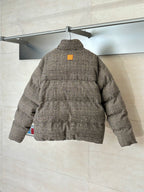 Back view of houndstooth puffer jacket with stand collar and yellow logo patch