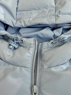 Light blue puffer jacket front zipper with metal pull and toggles