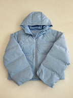 Light blue hooded puffer jacket, front view with zipper